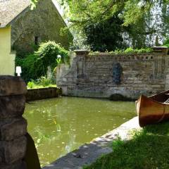 Un ancien canoë en bois sur la margelle du bassin au triton.